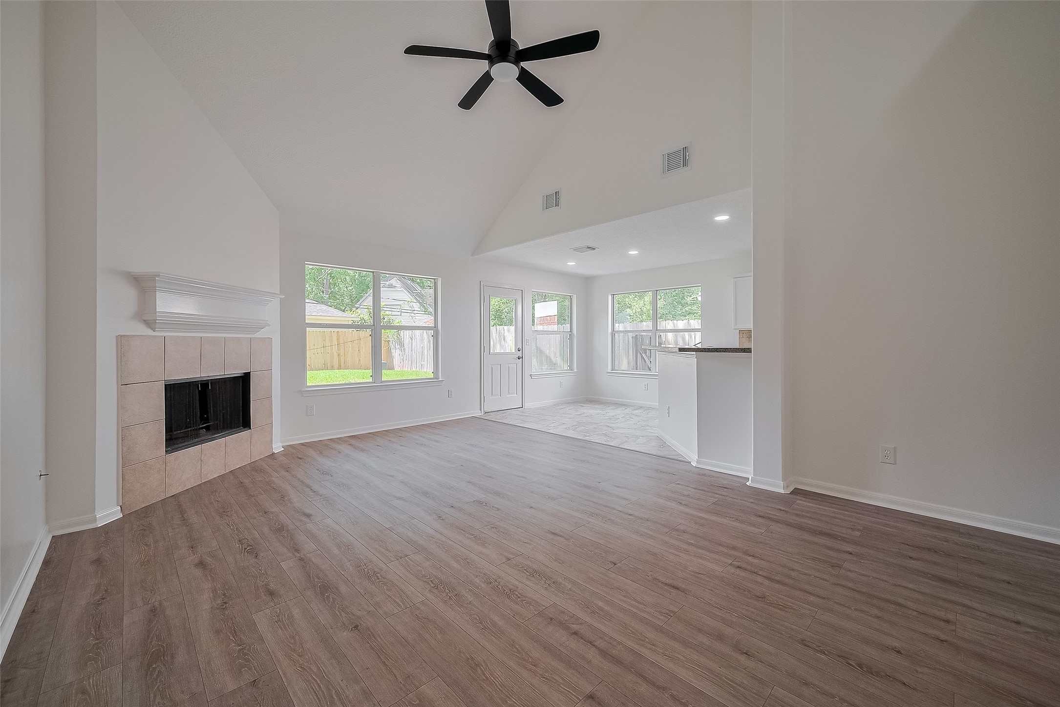 3223 Candlepine Drive Spring, TX 77388 - Photo 7 of 34 an empty room with wooden floor fireplace and windows