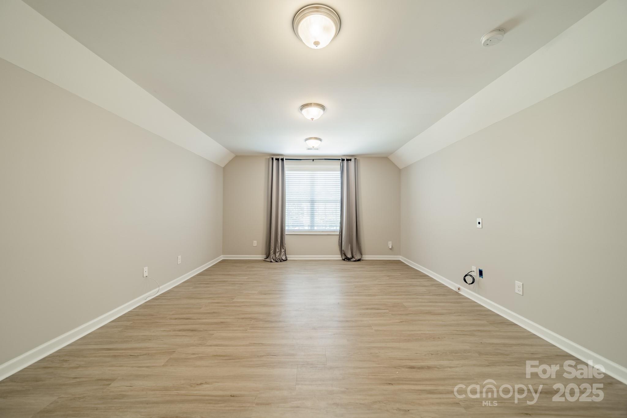 9229 Inverness Bay Road Charlotte, NC 28278 - Photo 18 of 41 a view of an empty room with wooden floor and a window