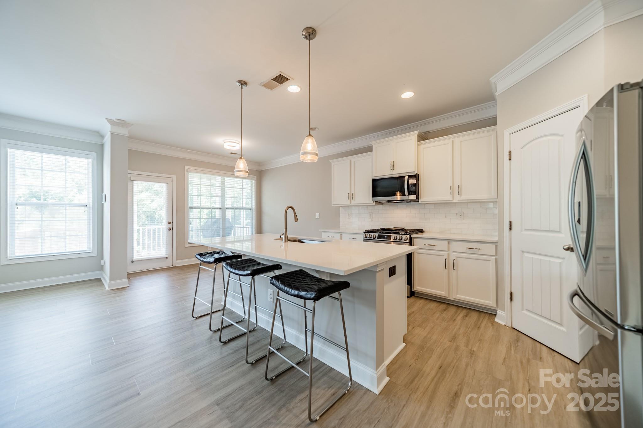 9229 Inverness Bay Road Charlotte, NC 28278 - Photo 9 of 41 a kitchen with stainless steel appliances granite countertop a sink a stove a refrigerator and wooden floor