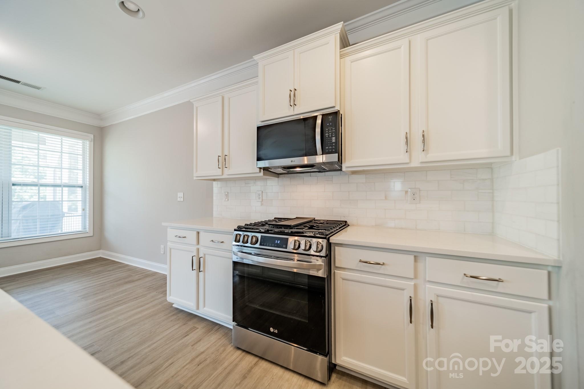 9229 Inverness Bay Road Charlotte, NC 28278 - Photo 10 of 41 a kitchen with stainless steel appliances granite countertop a stove a microwave and white cabinets