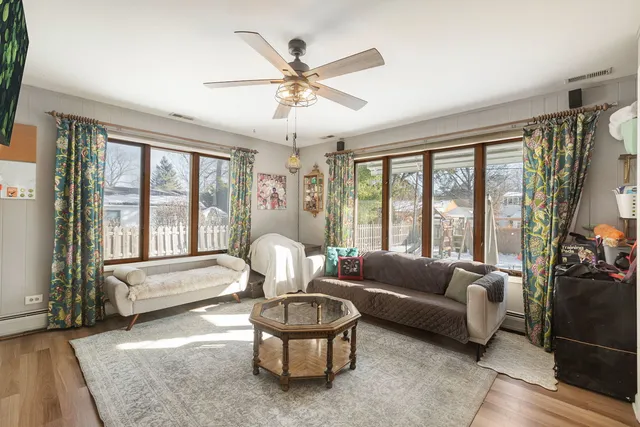 a living room with furniture and a large window with wooden floor