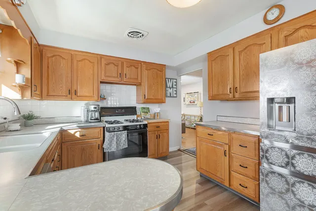 a kitchen with stainless steel appliances granite countertop a sink stove and refrigerator