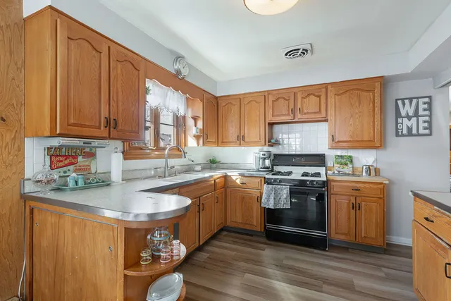 a kitchen with stainless steel appliances granite countertop a sink stove and refrigerator
