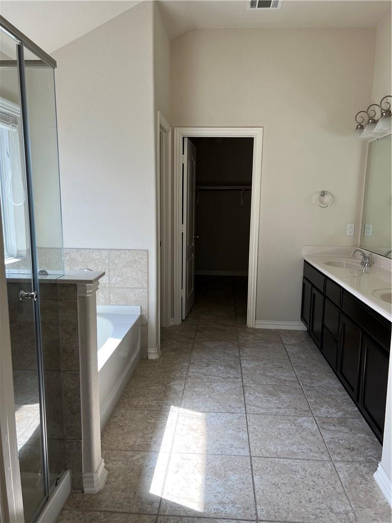 3645 Rams Horn Way Round Rock, TX 78665 - Photo 9 of 16 Bathroom featuring a spacious closet, double vanity, a stall shower, and a garden tub