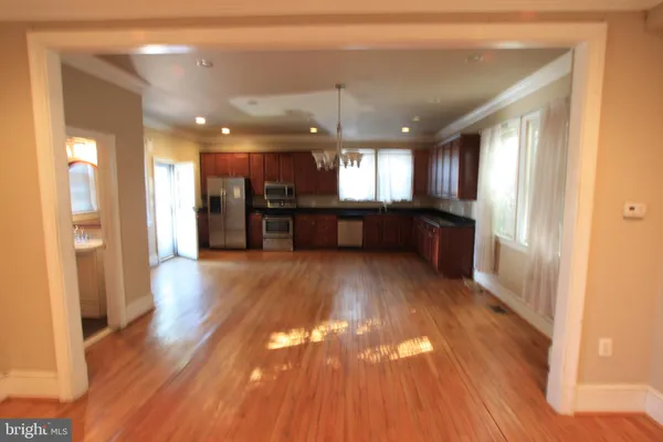 a large hall with wooden floor and a window