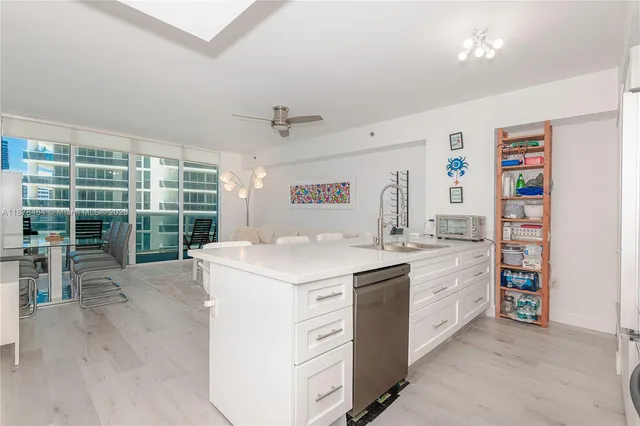 a view of kitchen with stainless steel appliances a sink and a large window
