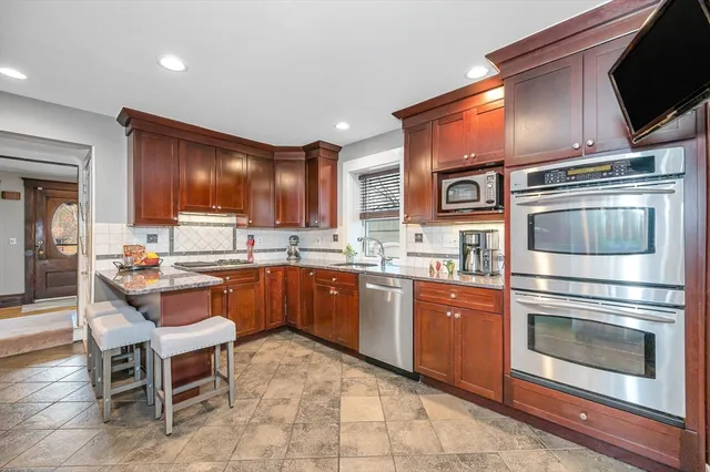 a kitchen with granite countertop stainless steel appliances and wooden cabinets