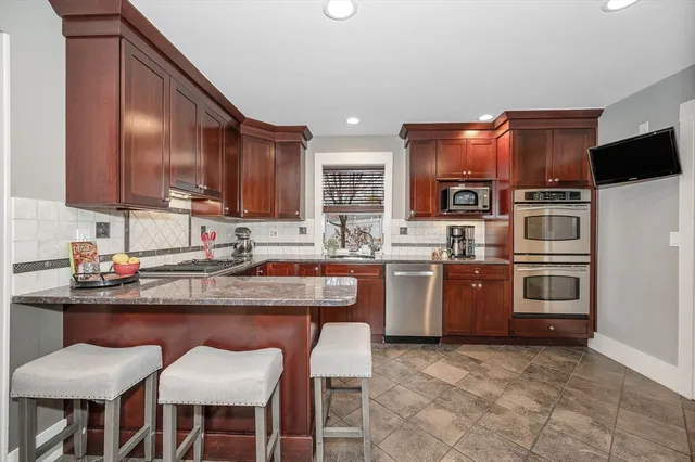 a kitchen with a sink and chairs