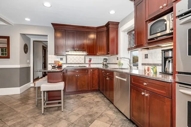 a kitchen with stainless steel appliances granite countertop a sink stove and cabinets