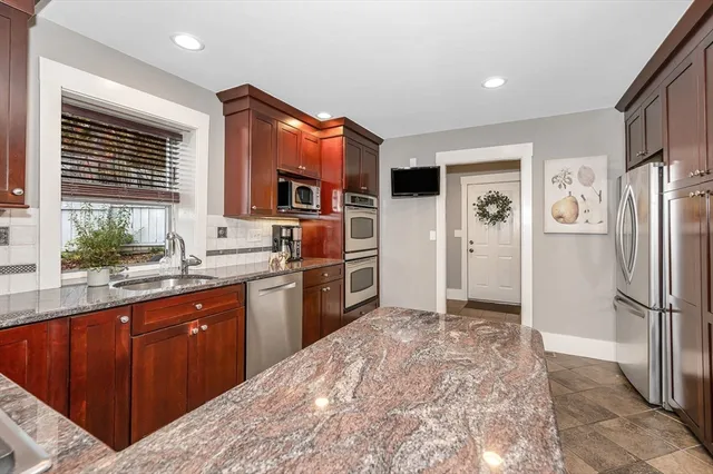 a kitchen with stainless steel appliances granite countertop a refrigerator and a sink