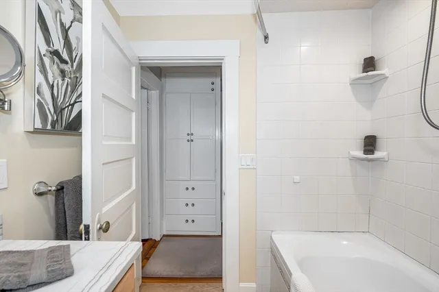 a view of a white house with large windows and a small yard