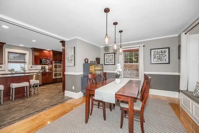 a view of a dining room and livingroom with furniture wooden floor a rug