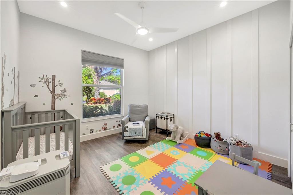 6900 Lone Oak Boulevard Naples, FL 34109 - Photo 12 of 23 a bedroom with furniture and a flat screen tv