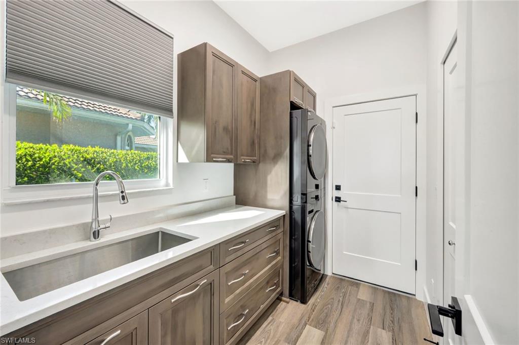 6900 Lone Oak Boulevard Naples, FL 34109 - Photo 13 of 23 a kitchen with a sink a counter top space stainless steel appliances and cabinets