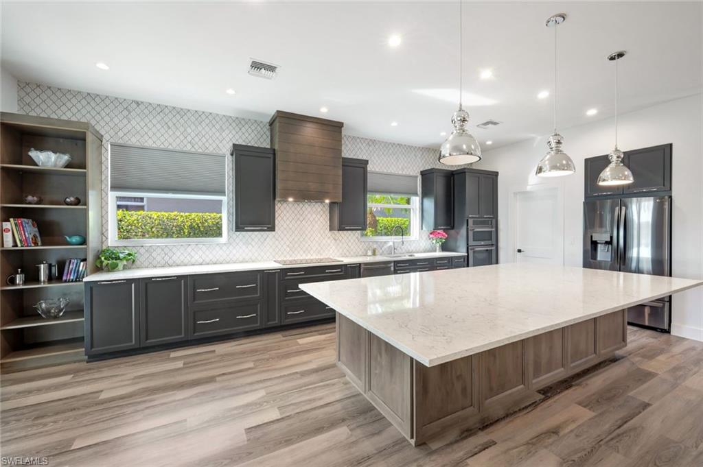6900 Lone Oak Boulevard Naples, FL 34109 - Photo 5 of 23 a large kitchen with stainless steel appliances a large counter top