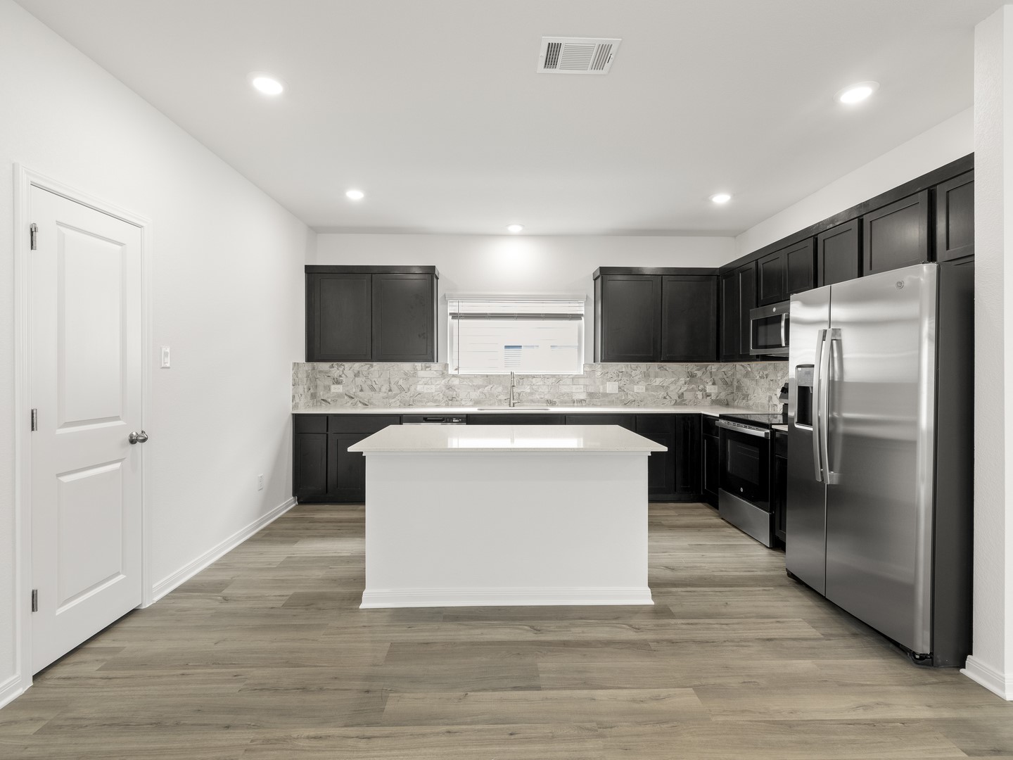 513 Yellow Ribbon Trail Jarrell, TX 76537 - Photo 5 of 23 A well-appointed kitchen showcasing a central island and a full suite of modern appliances.