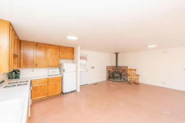 a view of a kitchen with a sink and dishwasher a oven with white cabinets