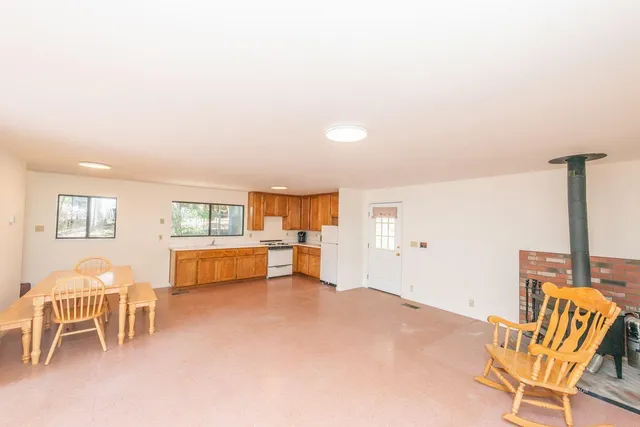 a living room with furniture and a dining table with chair