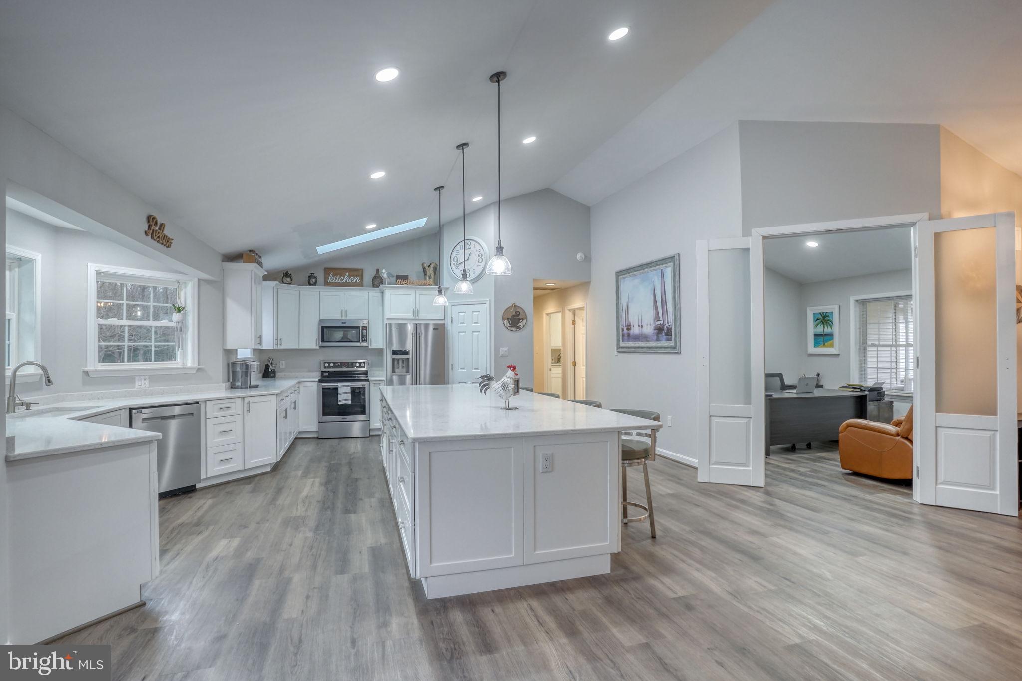 10821 Shawnee Road Harrington, DE 19952 - Photo 19 of 53 a large kitchen with kitchen island a sink dishwasher a stove a dining table and chairs
