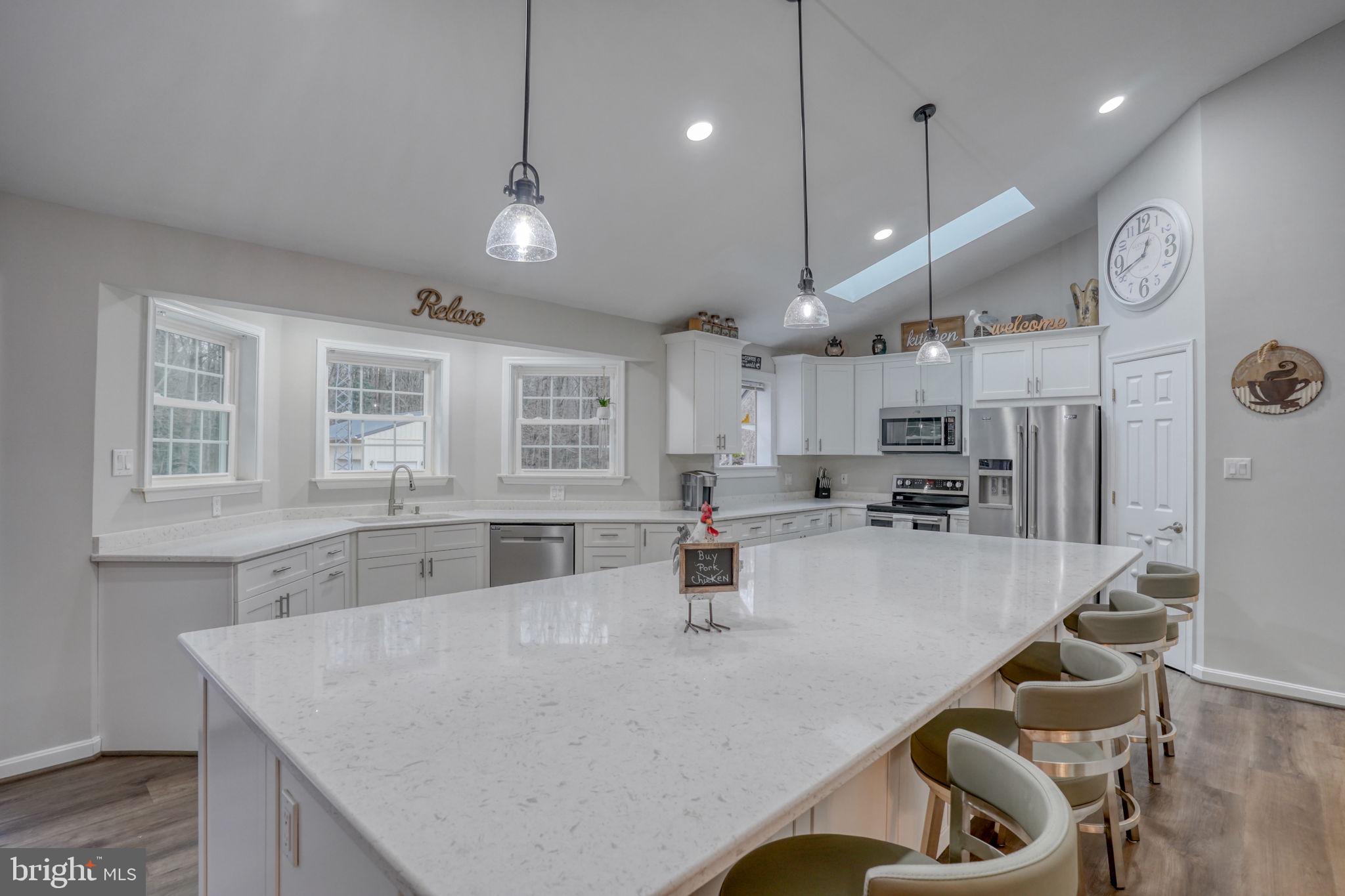 10821 Shawnee Road Harrington, DE 19952 - Photo 22 of 53 a large kitchen with kitchen island a large island a sink a stove and a chandelier