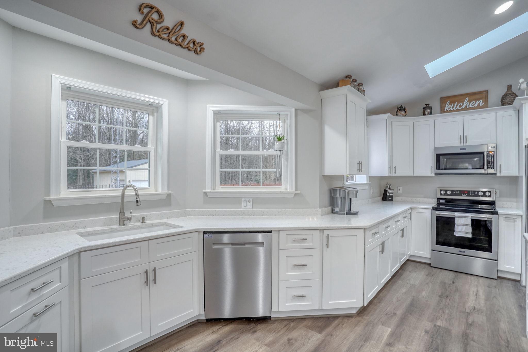 10821 Shawnee Road Harrington, DE 19952 - Photo 23 of 53 a kitchen with stainless steel appliances granite countertop a sink a stove a refrigerator cabinets and a window