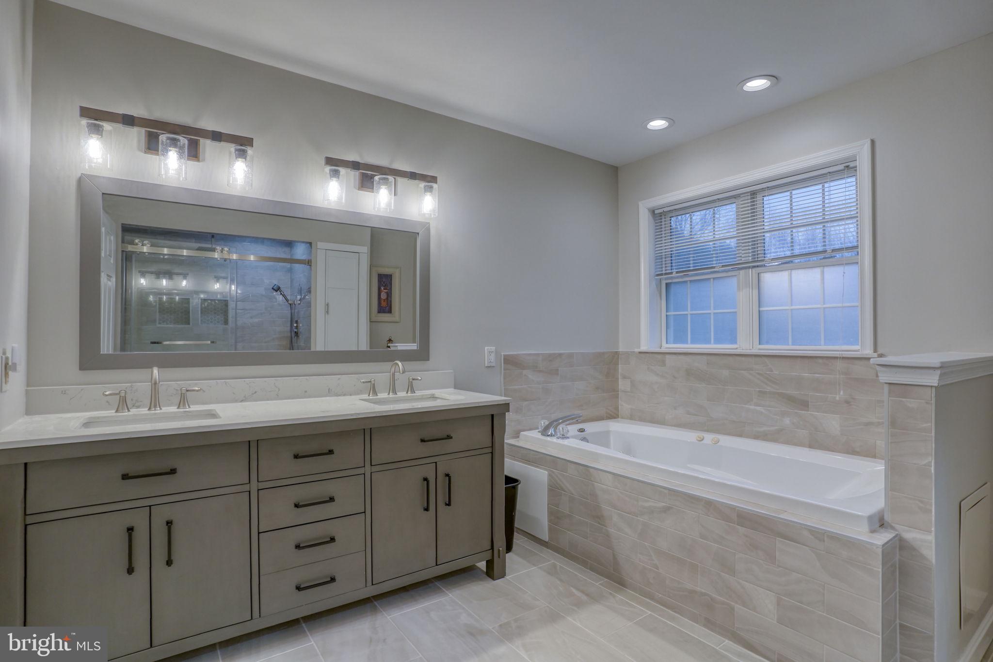 10821 Shawnee Road Harrington, DE 19952 - Photo 37 of 53 a bathroom with a granite countertop sink a large mirror a bathtub and window