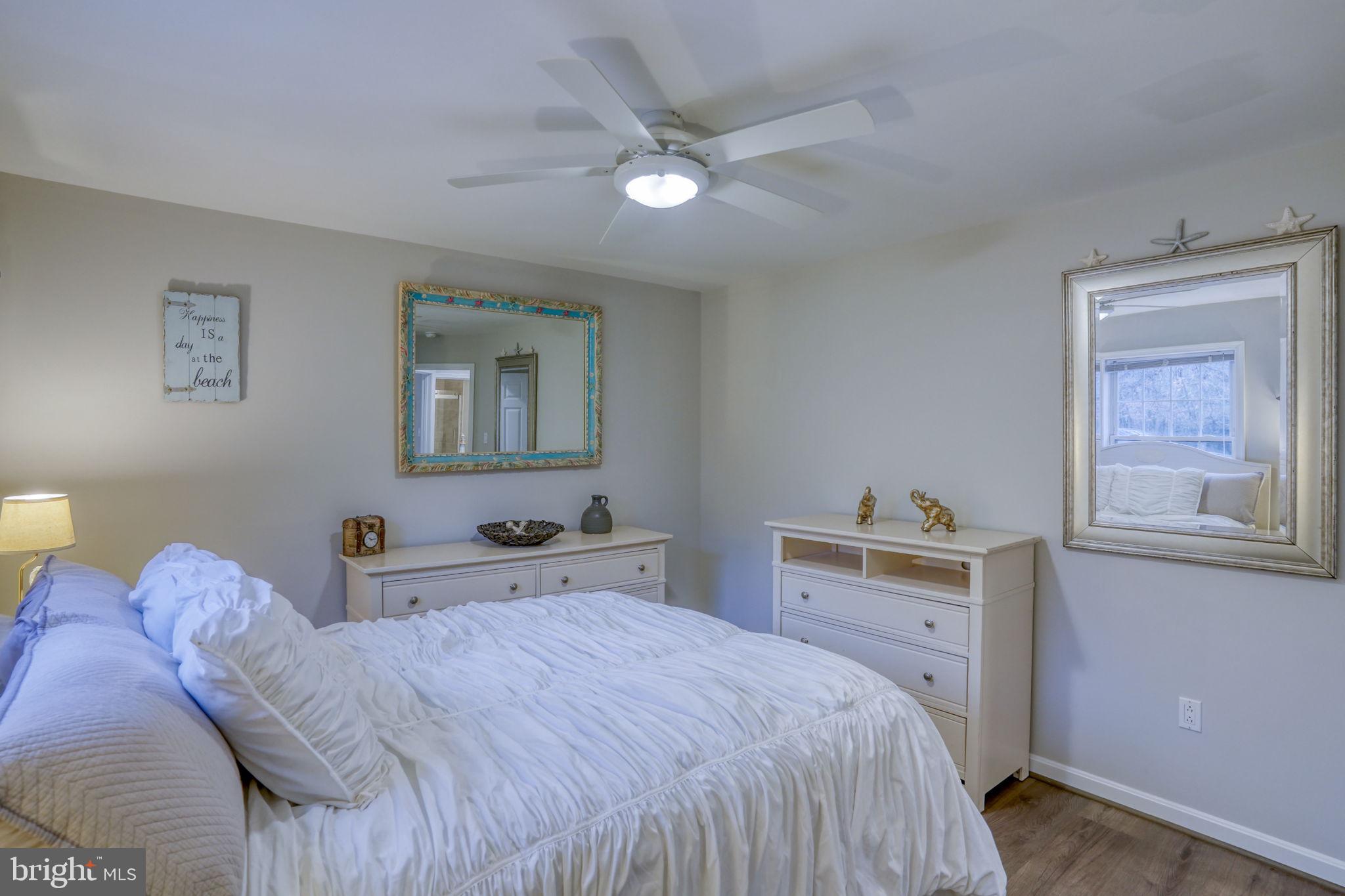 10821 Shawnee Road Harrington, DE 19952 - Photo 42 of 53 a bedroom with a large bed and a chandelier