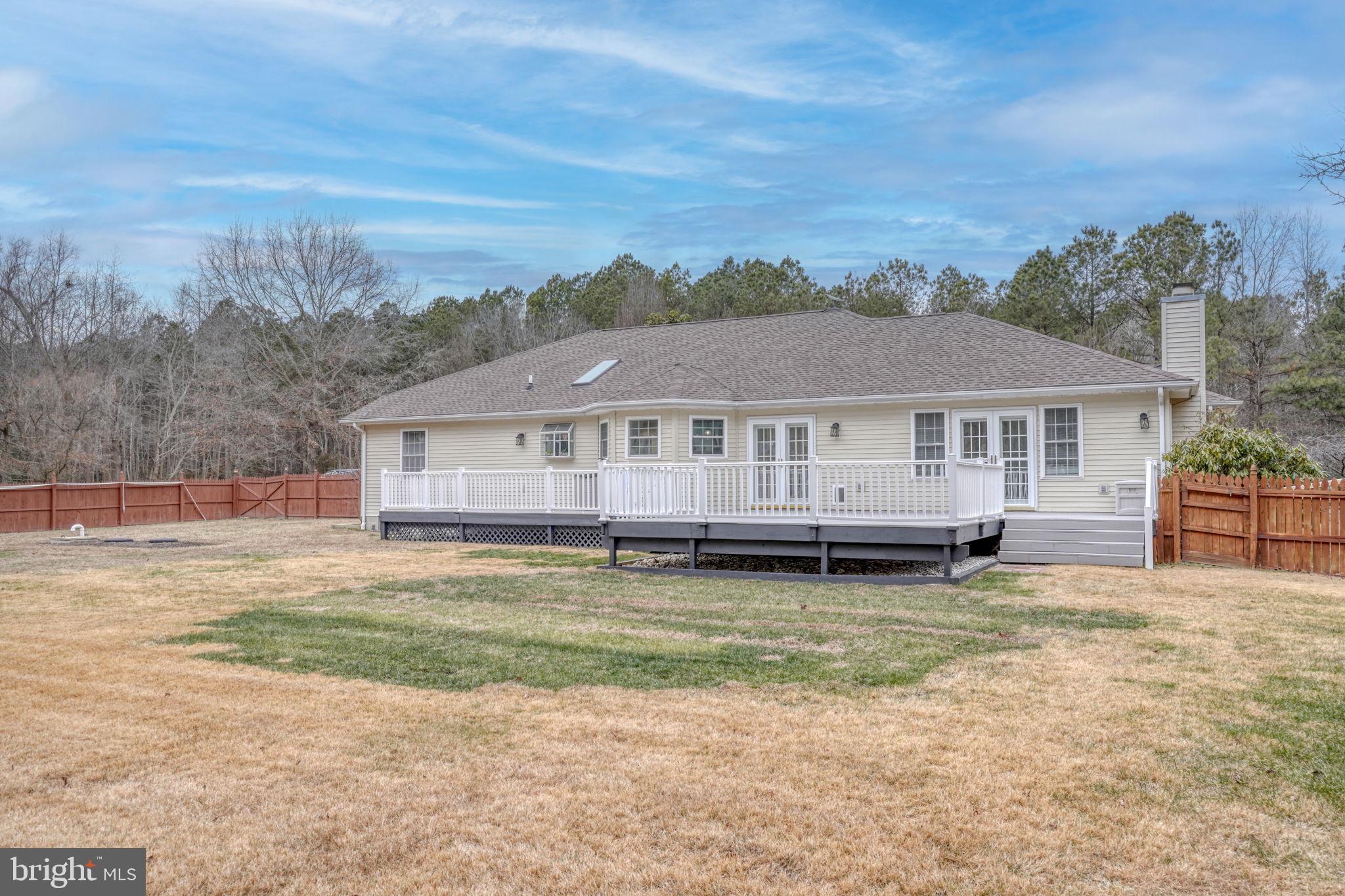 10821 Shawnee Road Harrington, DE 19952 - Photo 7 of 53 a white house sitting in middle of the middle of a field