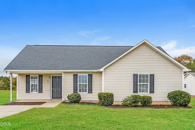a backyard of a house with potted plants and floor to ceiling window