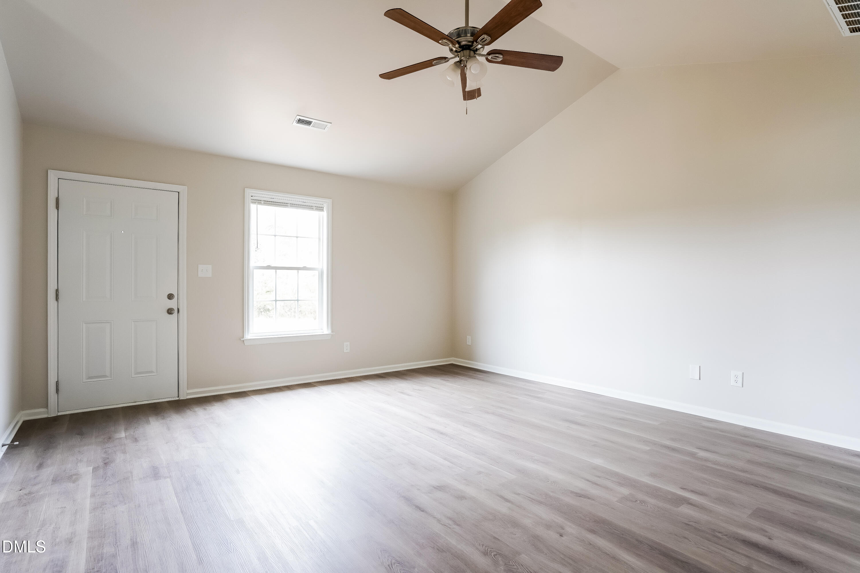 77 Jethro Circle Smithfield, NC 27577 - Photo 2 of 16 an empty room with wooden floor fan and windows
