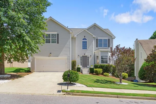 a front view of a house with a yard and garage
