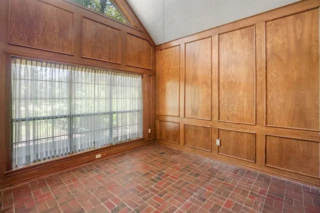 a view of an empty room with a fireplace and a window