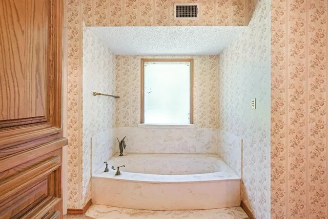 a bathroom with a granite countertop toilet and sink