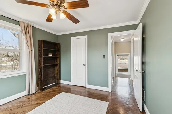 an empty room with closet and a chandelier fan