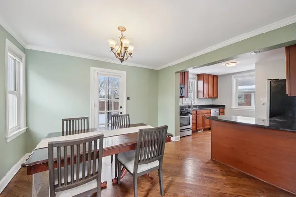 a view of a dining room with furniture a chandelier and wooden floor