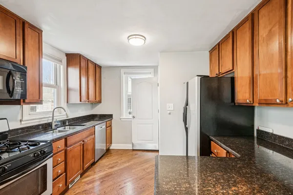 a kitchen with stainless steel appliances granite countertop a refrigerator stove and sink