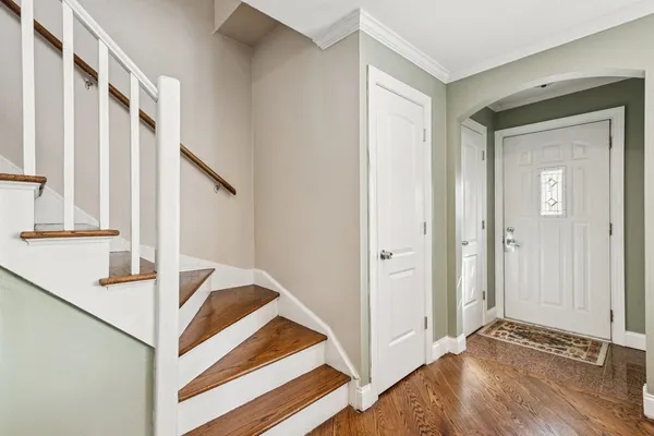 a view of a hallway with staircase and white walls