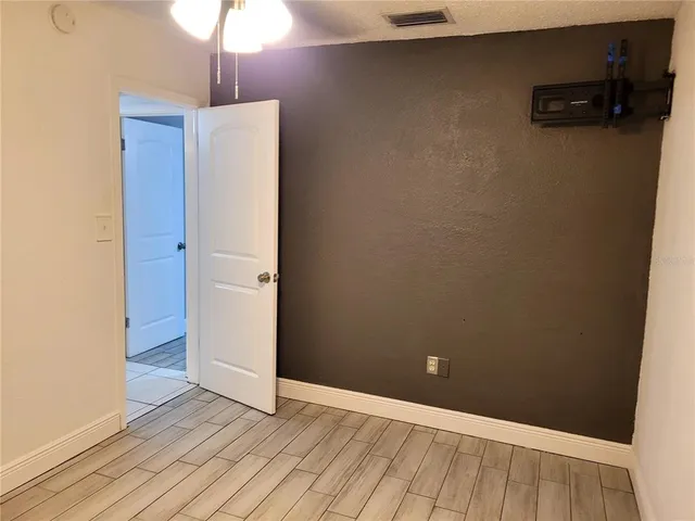 a view of an empty room with wooden floor