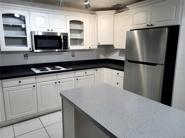 a kitchen with stainless steel appliances a refrigerator a stove a microwave and cabinets