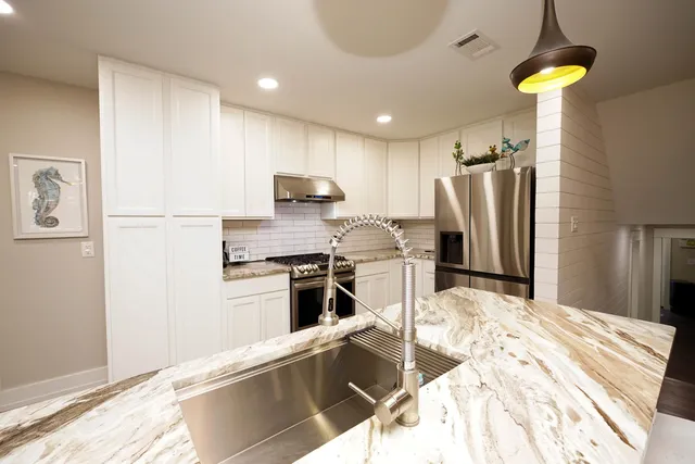 a kitchen with kitchen island a counter top space appliances and cabinets