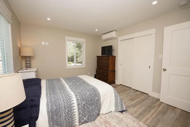 a bedroom with a bed and wooden floor