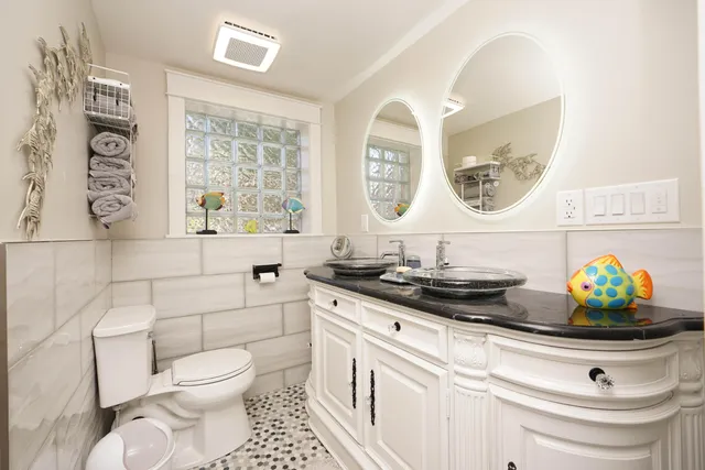 a bathroom with a granite countertop toilet sink and mirror