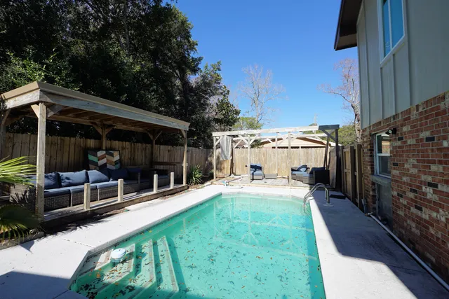 a view of a patio with table and chairs and wooden fence