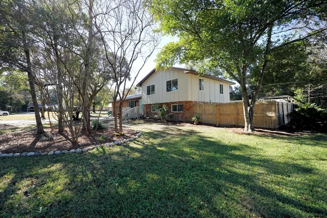 a front view of a house with a yard and tree