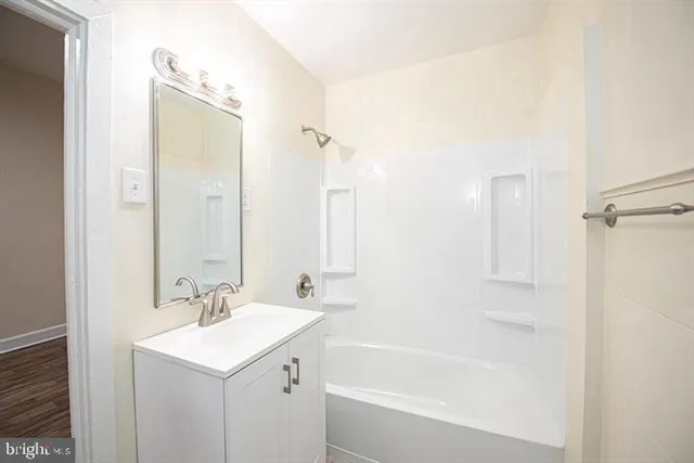 a bathroom with a bath tub sink mirror and a shower