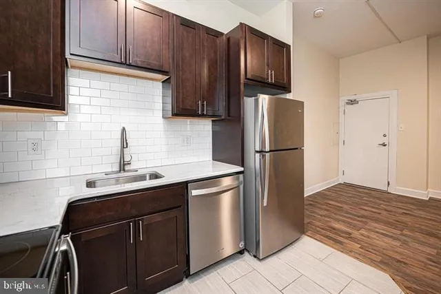 a kitchen with stainless steel appliances granite countertop a refrigerator and a sink