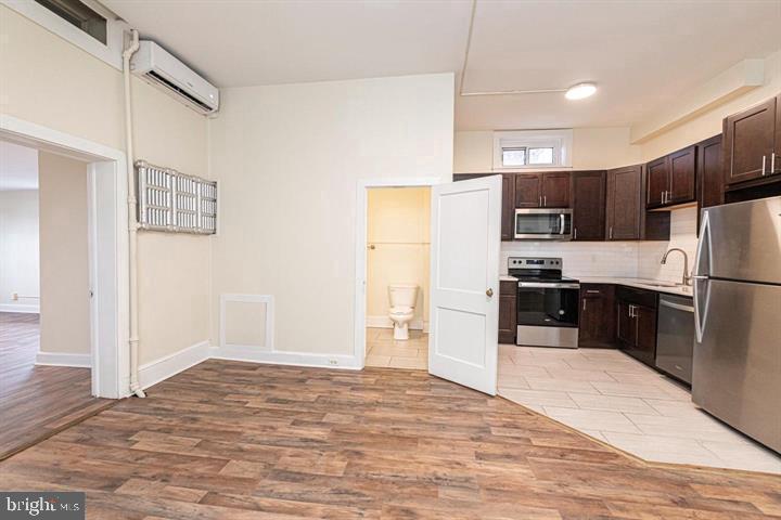 215 Bridge Street, Unit B Phoenixville, PA 19460 - Photo 10 of 31 a kitchen with stainless steel appliances a refrigerator and a stove top oven