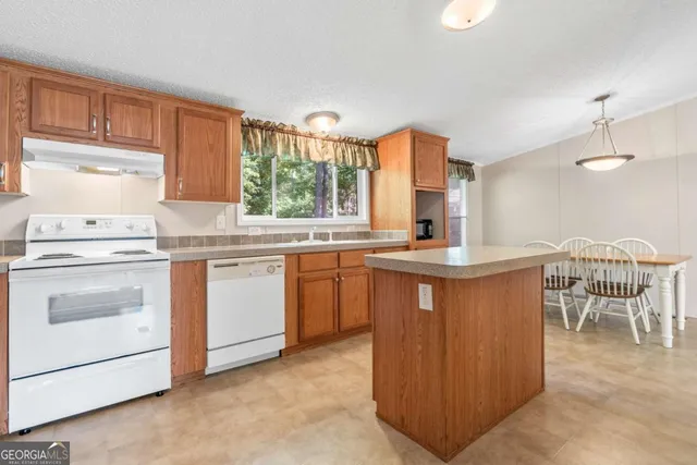a kitchen with granite countertop white cabinets and white appliances