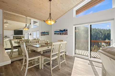 a view of a dining room and livingroom with furniture wooden floor a chandelier