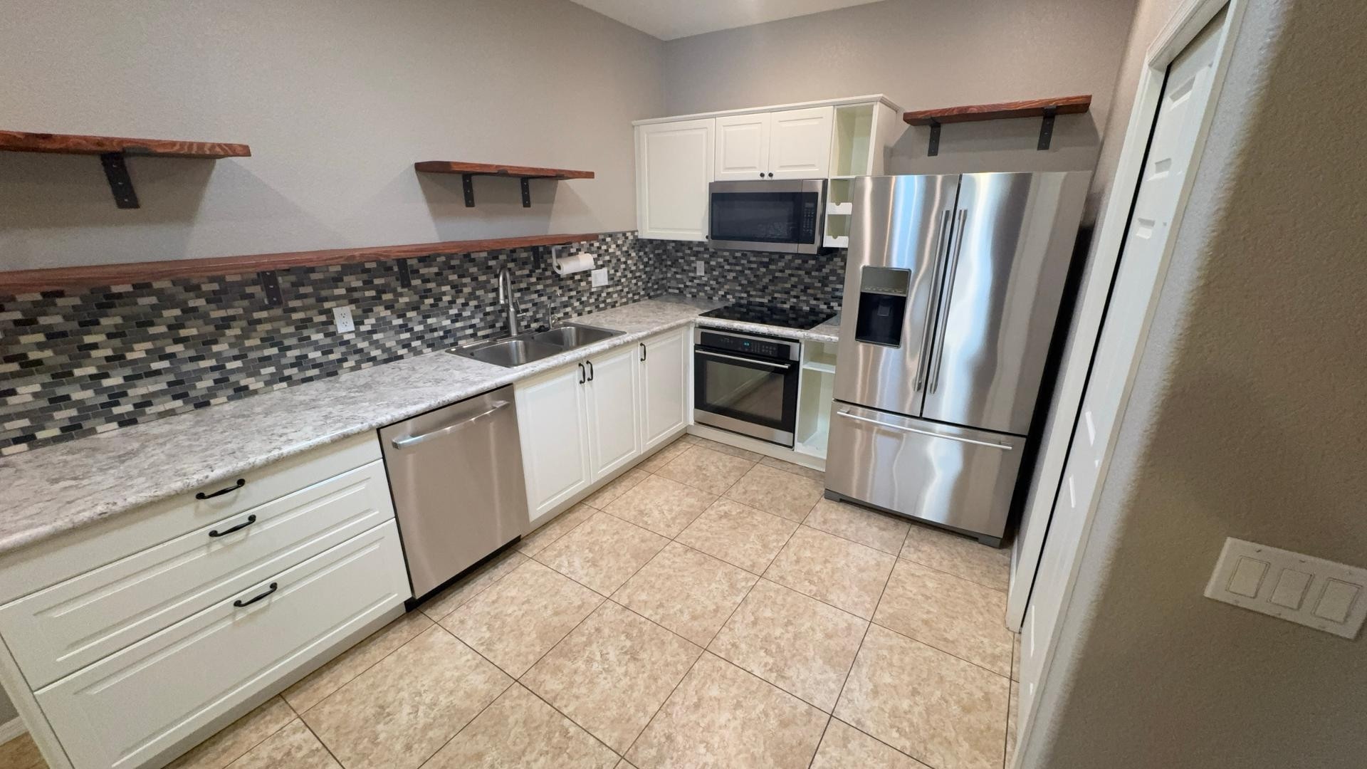 a kitchen with granite countertop a refrigerator stove and sink